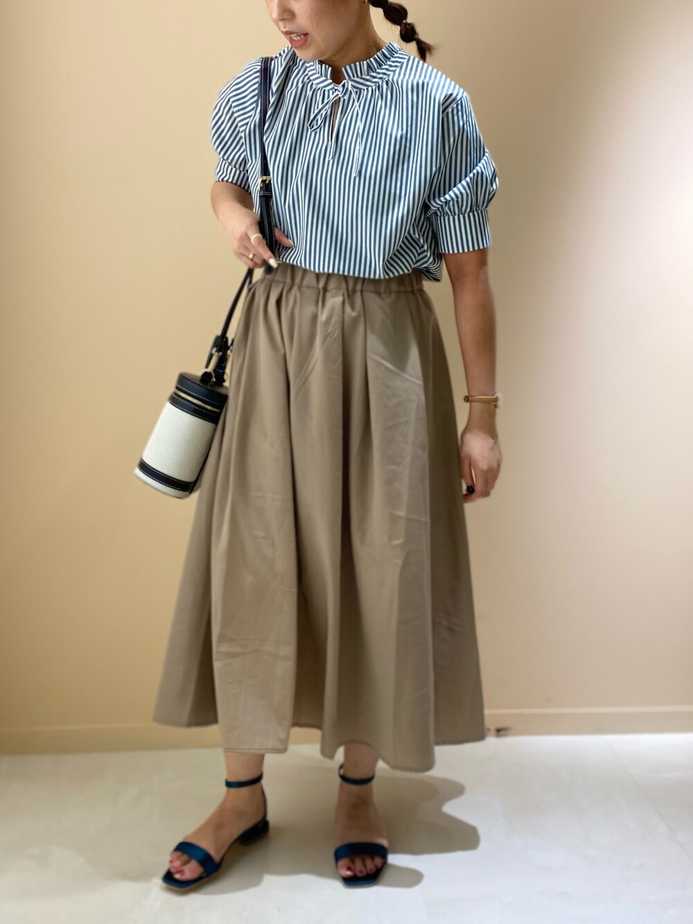 ブラウン系のスカート、グリーン系のサンダル、ブラック系のショルダーバッグを着用したレディースの夏コーディネートの3枚目の写真