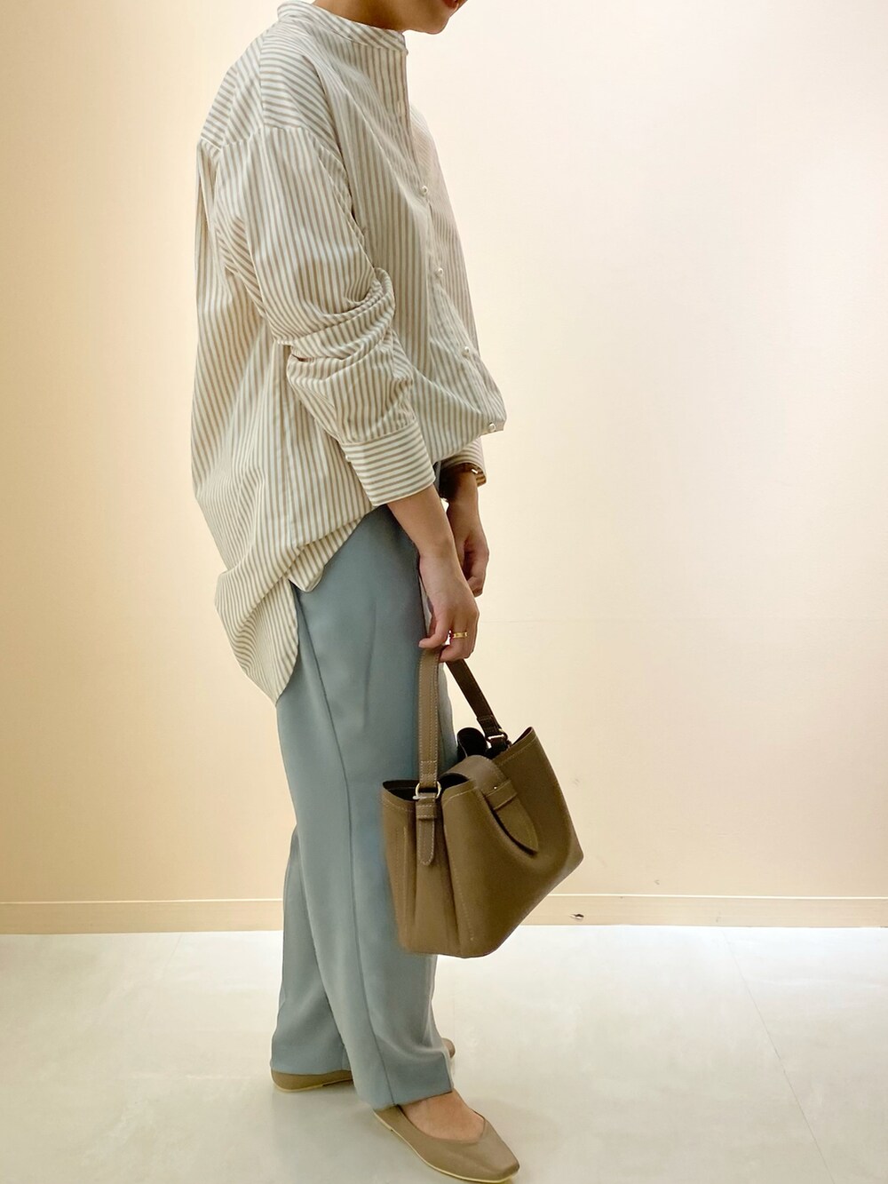 ブラウン系のショルダーバッグ、ブラウン系のパンプス、ベージュ系のシャツ/ブラウスを着用したレディースの春コーディネートの2枚目の写真