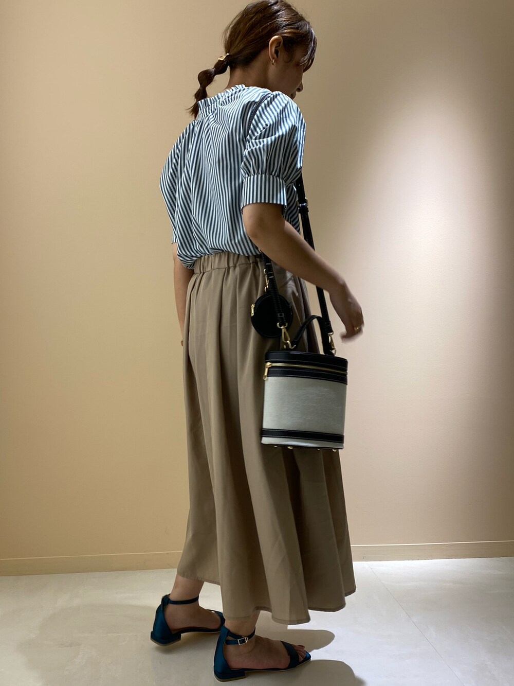 ブラウン系のスカート、グリーン系のサンダル、ブラック系のショルダーバッグを着用したレディースの夏コーディネートの4枚目の写真