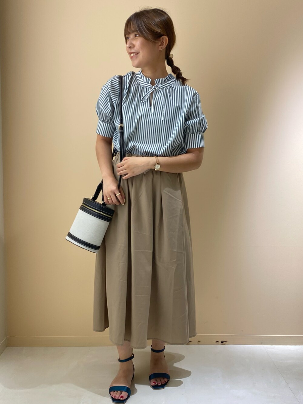 ブラウン系のスカート、グリーン系のサンダル、ブラック系のショルダーバッグを着用したレディースの夏コーディネートの2枚目の写真