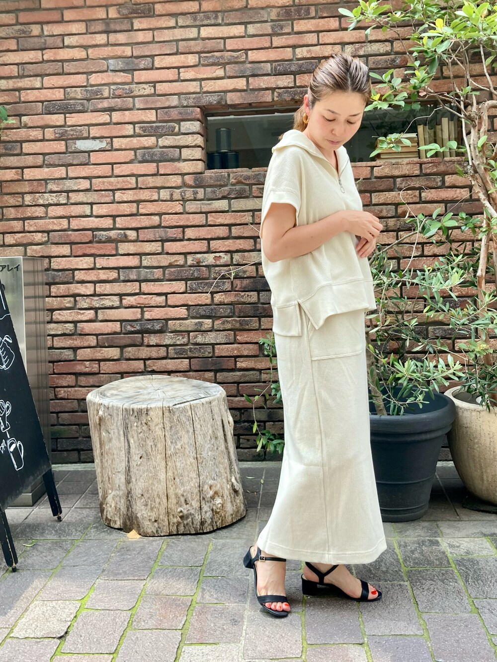 ブラック系のサンダル、ホワイト系のスカート、ホワイト系のTシャツ/カットソーを着用したレディースの夏コーディネートの2枚目の写真