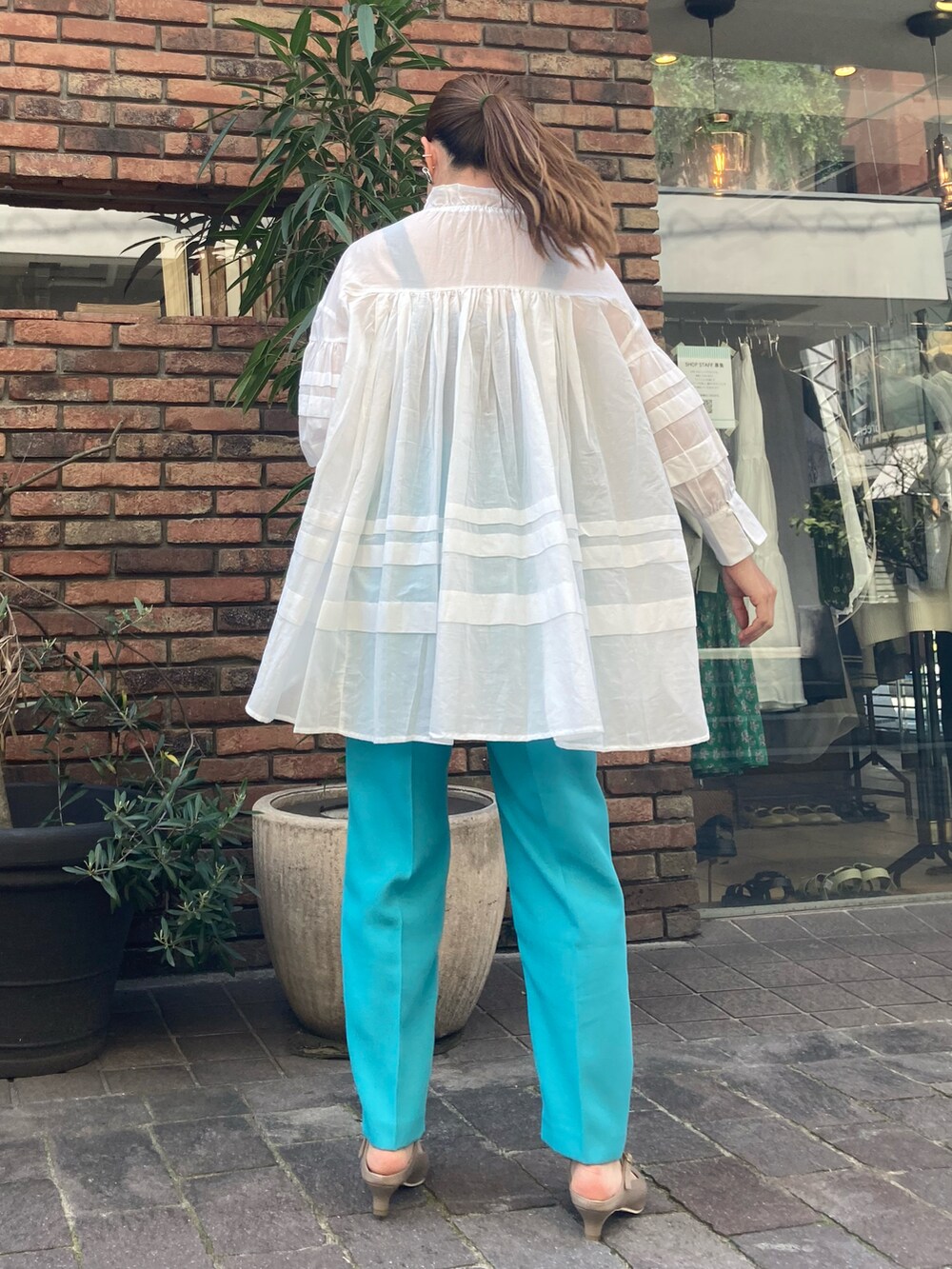 ブルー系のその他パンツ、ホワイト系のシャツ/ブラウス、ブラウン系のパンプスを着用したレディースの春コーディネートの2枚目の写真