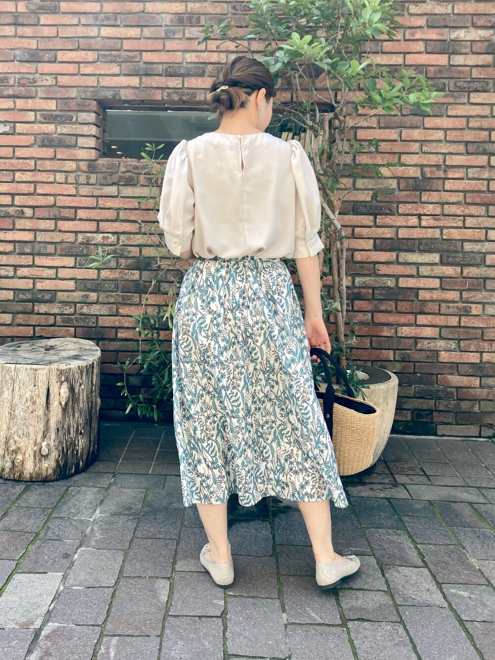 ベージュ系のシャツ/ブラウス、グリーン系のスカート、ベージュ系のパンプスを着用したレディースの春コーディネートの2枚目の写真