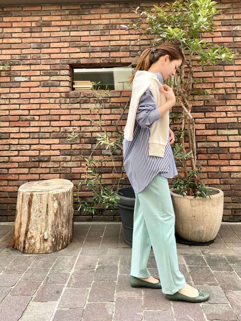 ホワイト系のカーディガン/ボレロ、ブルー系のシャツ/ブラウス、グリーン系のパンプスを着用したレディースの春コーディネートの2枚目の写真