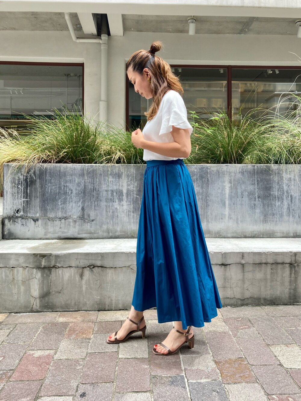 ホワイト系のニット/セーター、グリーン系のスカート、グリーン系のサンダルを着用したレディースの夏コーディネートの2枚目の写真