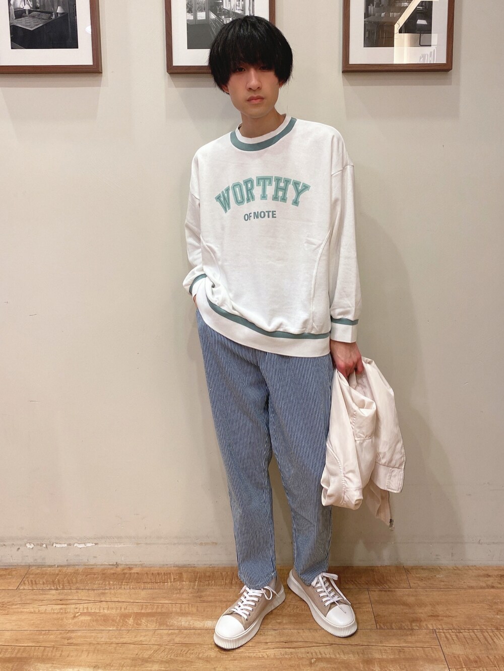 ベージュ系のブルゾン、ホワイト系のスウェット、ブルー系のデニムパンツを着用したメンズの冬コーディネートの3枚目の写真