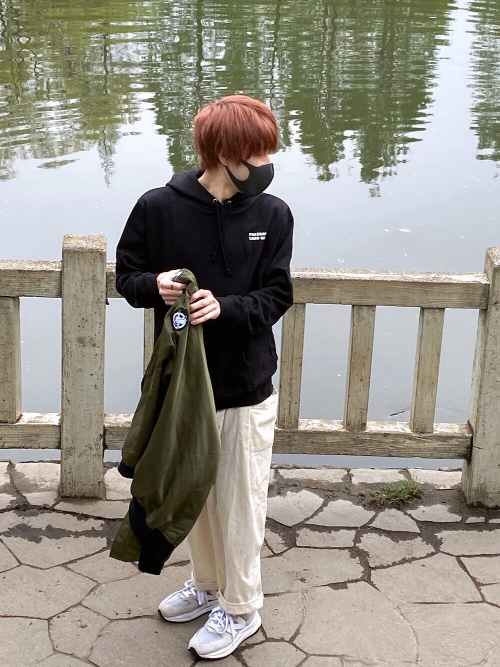 グリーン系のブルゾン、ブラック系のパーカー、ホワイト系のその他パンツを着用したメンズの春コーディネートの3枚目の写真