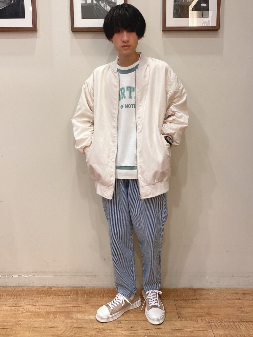 ベージュ系のブルゾン、ホワイト系のスウェット、ブルー系のデニムパンツを着用したメンズの冬コーディネートの2枚目の写真