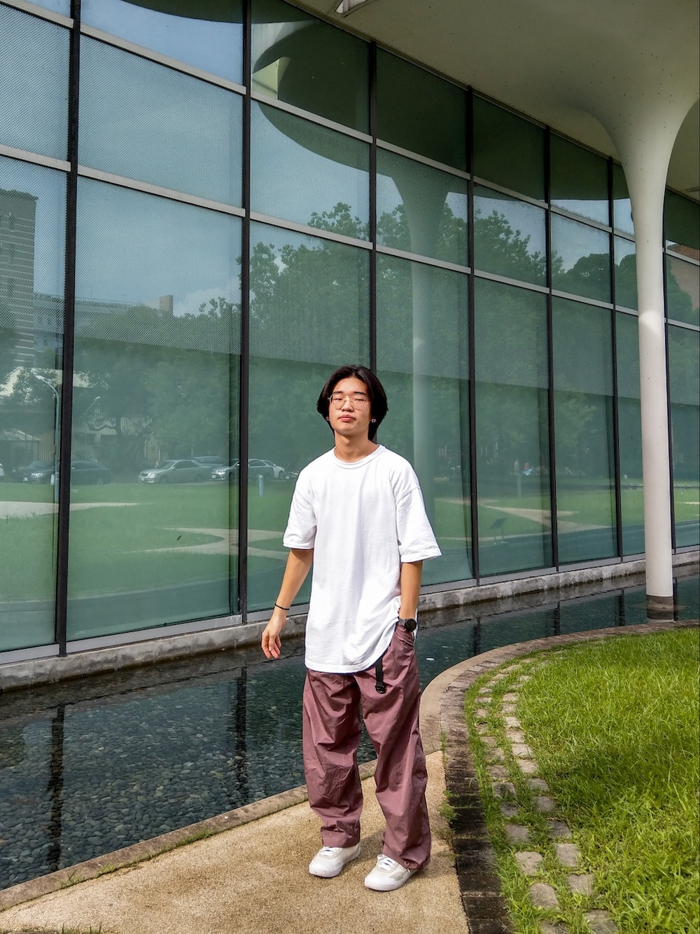 レッド系のパンツ、ホワイト系のトップス、ホワイト系のシューズを着用したメンズの夏コーディネートの2枚目の写真