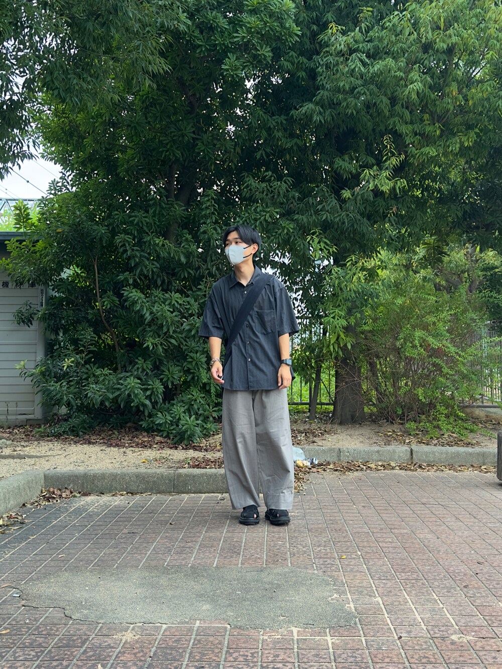 グレー系のシャツ/ブラウス、グレー系のショルダーバッグ、ベージュ系のスラックスを着用したメンズの夏コーディネートの3枚目の写真
