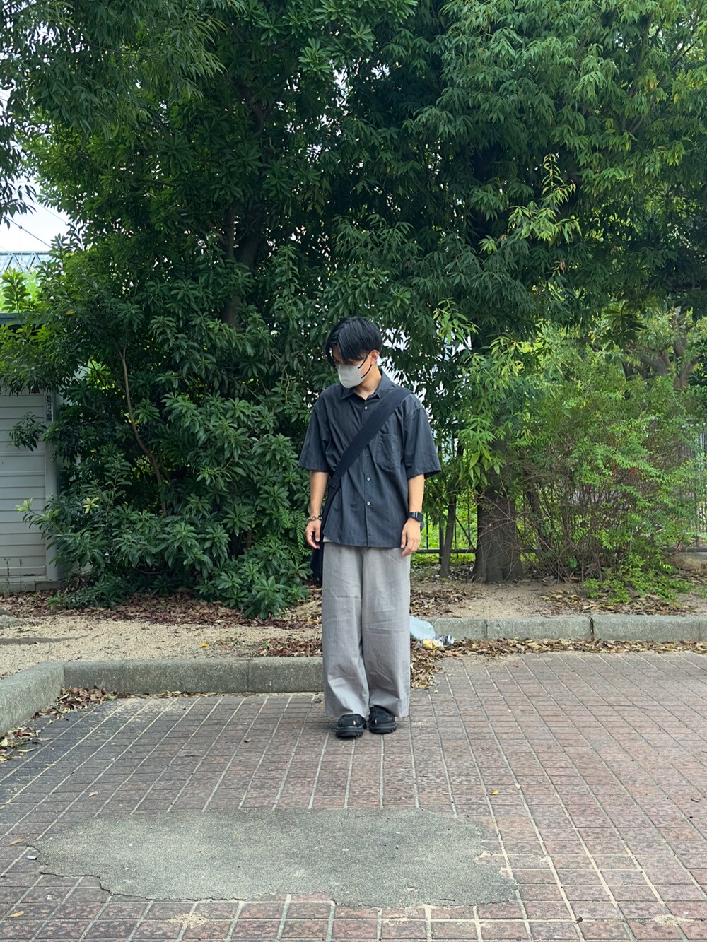 グレー系のシャツ/ブラウス、グレー系のショルダーバッグ、ベージュ系のスラックスを着用したメンズの夏コーディネートの2枚目の写真