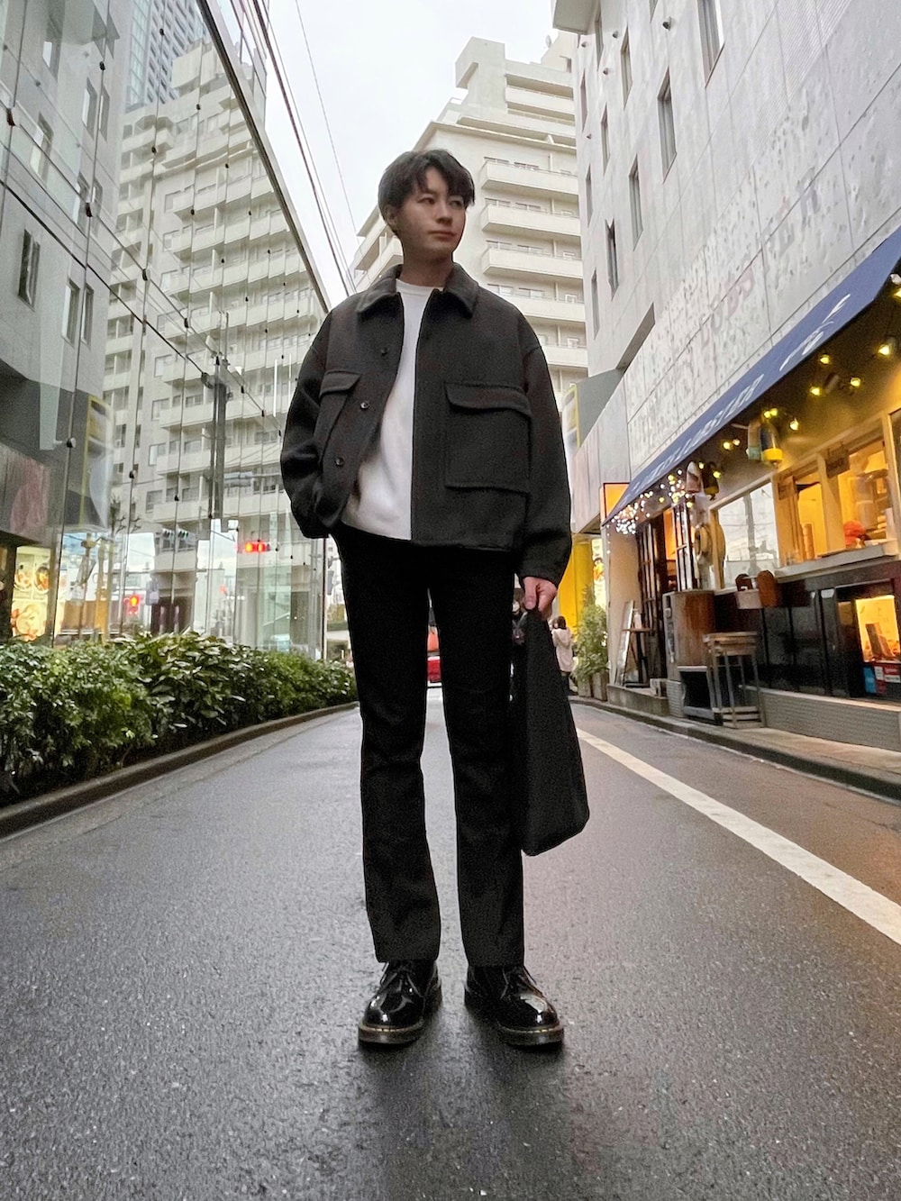 グレー系のブルゾン、ホワイト系のニット/セーター、ブラック系のスラックスを着用したメンズの冬コーディネートの2枚目の写真