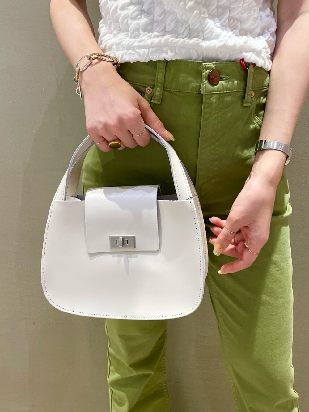 グリーン系のデニムパンツ、ホワイト系のサンダルを着用したレディースの夏コーディネートの5枚目の写真