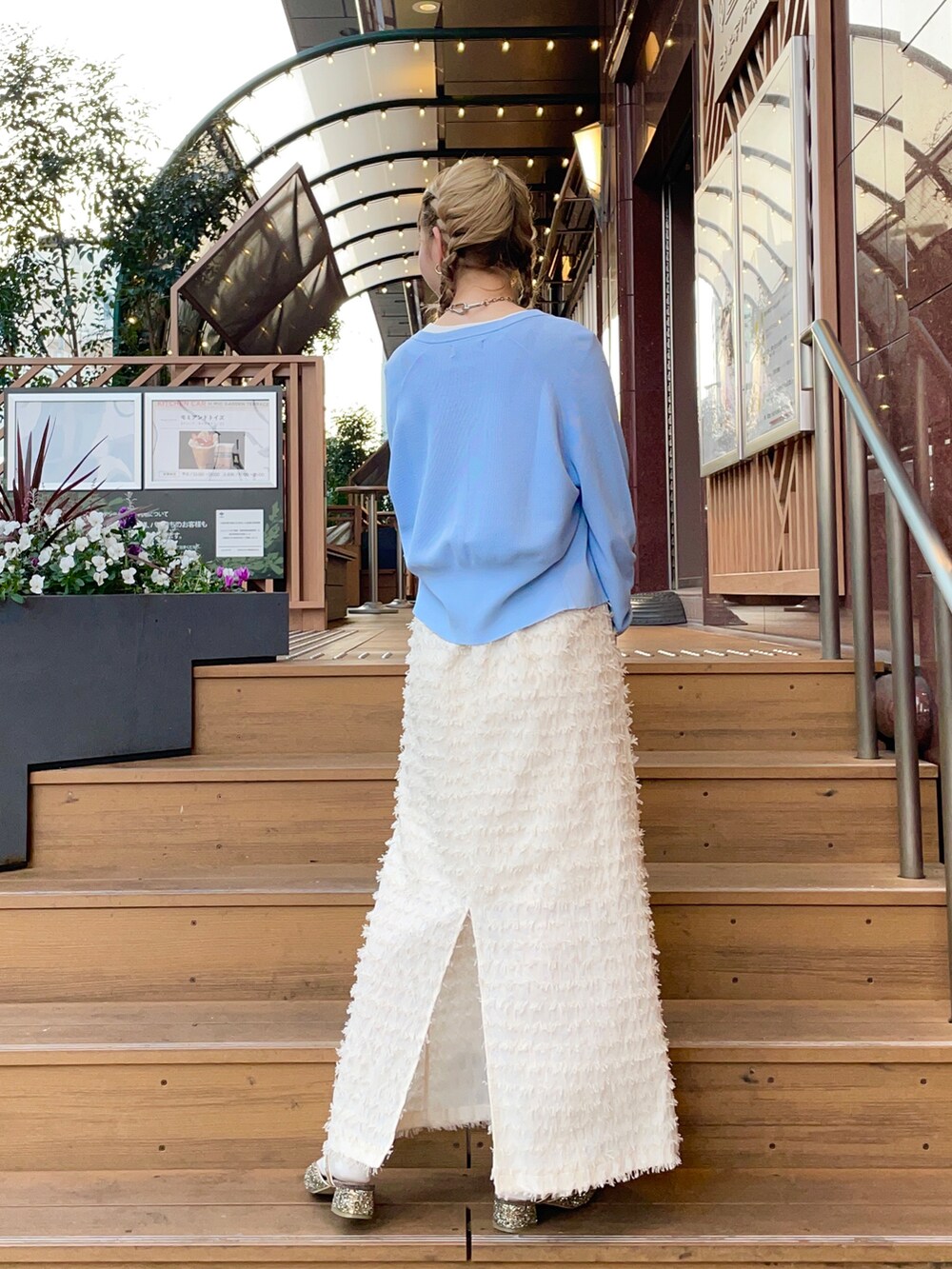 グリーン系のバッグ、ブルー系のカーディガン/ボレロ、ブルー系のベストを着用したレディースの冬コーディネートの2枚目の写真