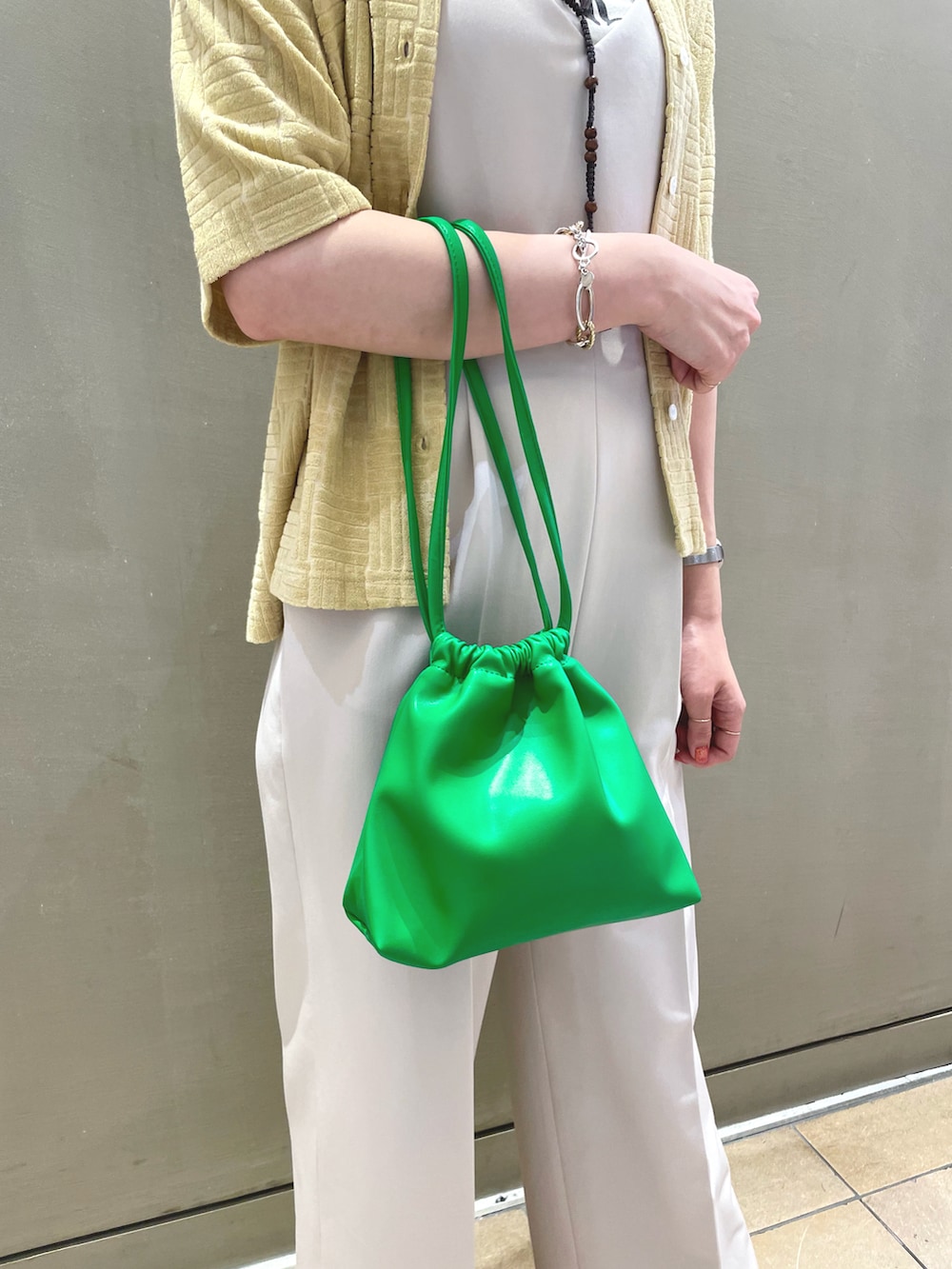 ホワイト系のサロペット/オーバーオール、イエロー系のシャツ/ブラウス、グリーン系のショルダーバッグを着用したレディースの夏コーディネートの3枚目の写真