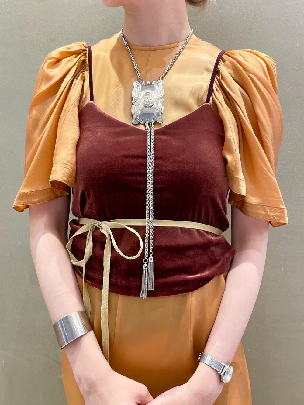 シルバー系のパンプス、ブラウン系のキャミソール、オレンジ系のワンピースを着用したレディースの夏コーディネートの4枚目の写真