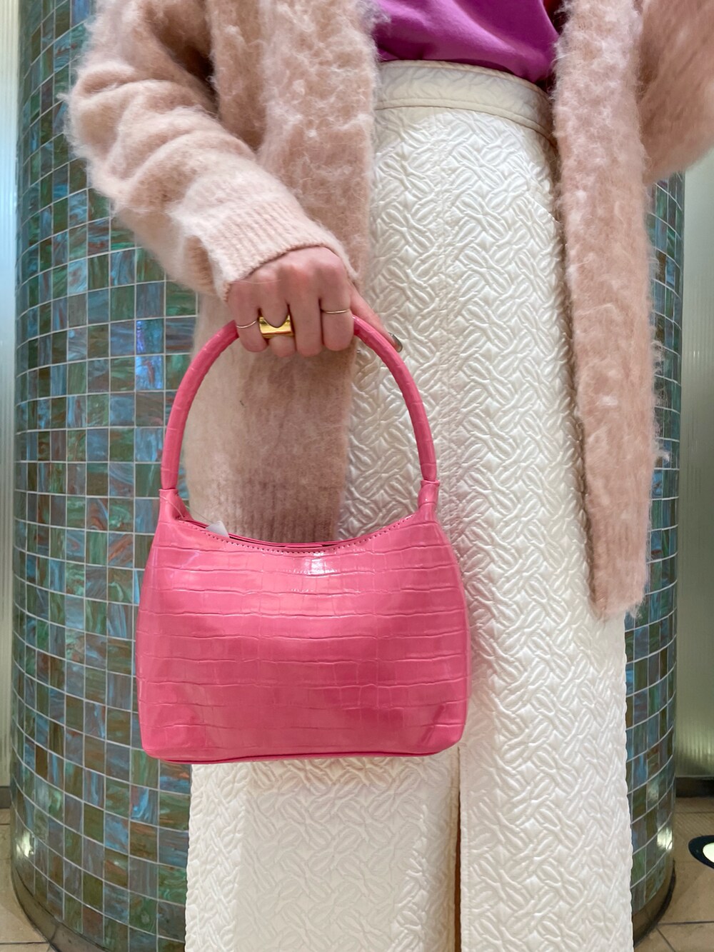 ピンク系のカーディガン/ボレロ、ピンク系のTシャツ/カットソー、ホワイト系のスカートを着用したレディースの冬コーディネートの5枚目の写真