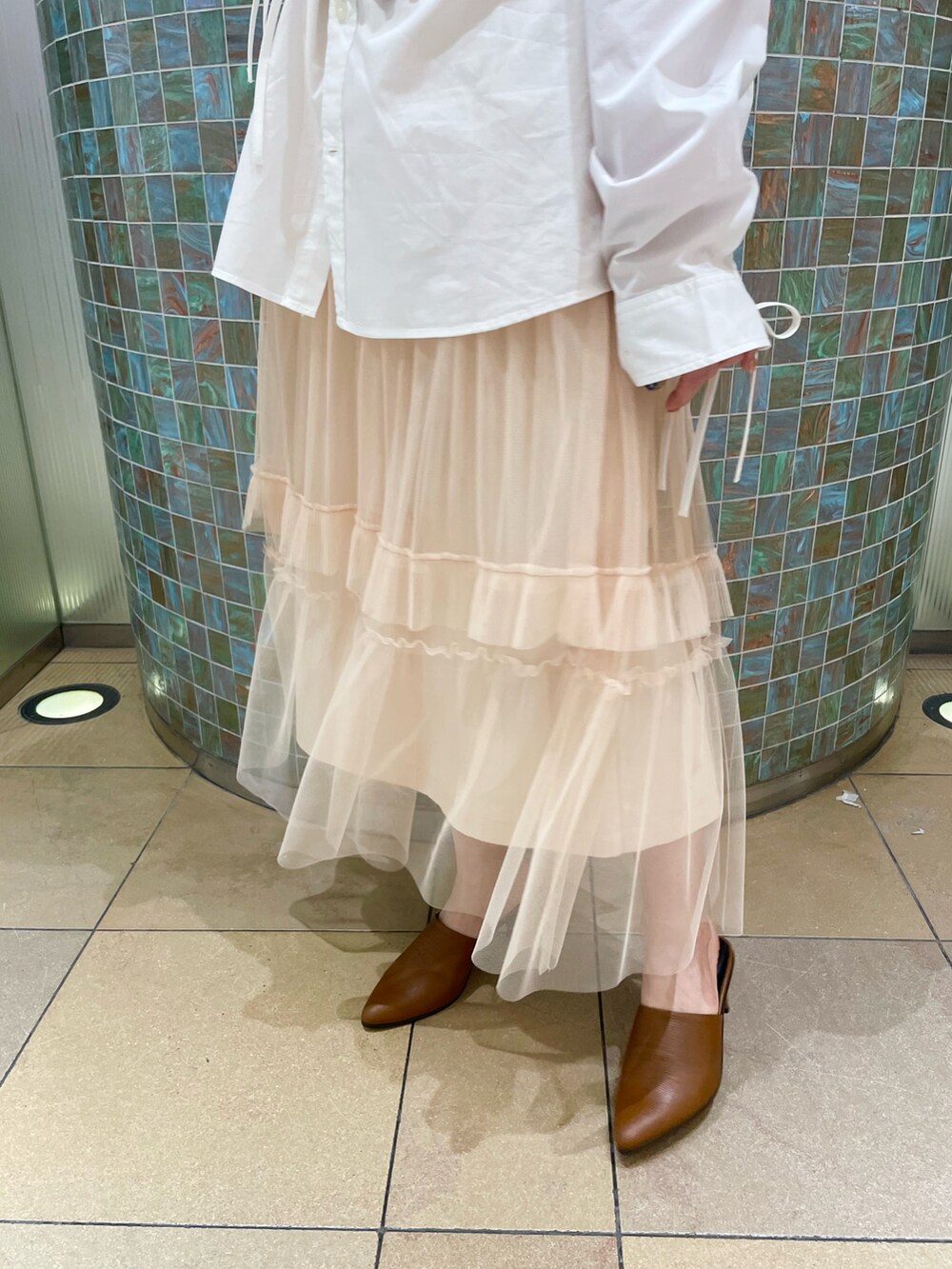 ベージュ系のスカート、ピンク系のトップスを着用したレディースの冬コーディネートの5枚目の写真