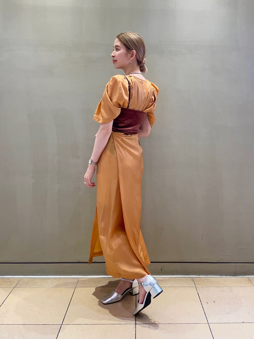 シルバー系のパンプス、ブラウン系のキャミソール、オレンジ系のワンピースを着用したレディースの夏コーディネートの2枚目の写真