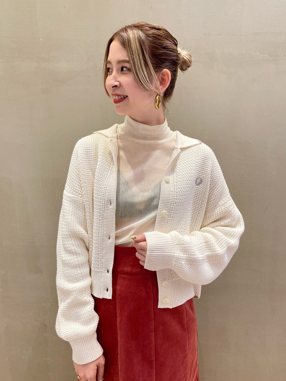 ホワイト系のカーディガン/ボレロ、ブラウン系のスカート、ホワイト系のTシャツ/カットソーを着用したレディースの秋コーディネートの2枚目の写真