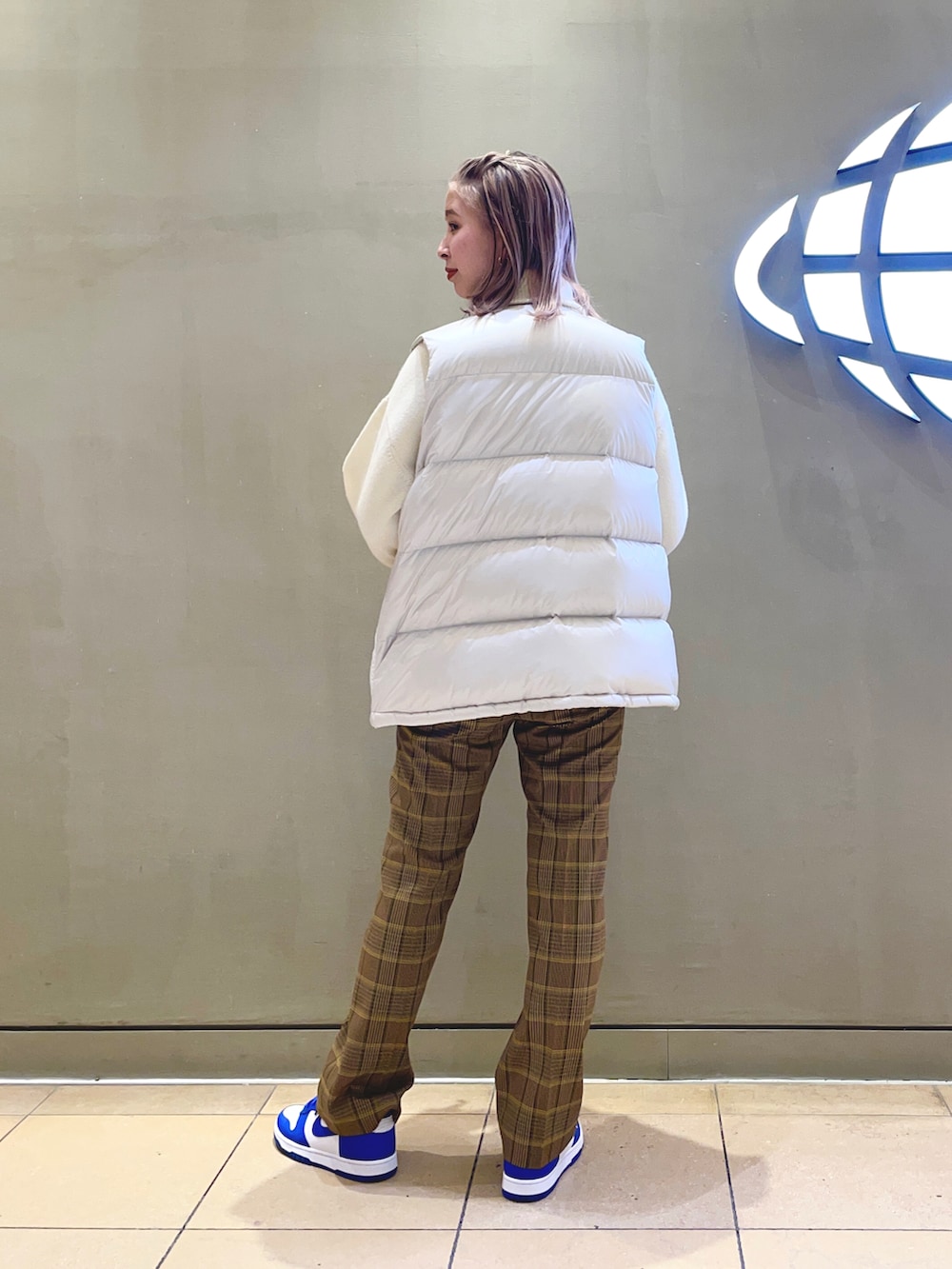 ベージュ系のその他パンツ、ホワイト系のダウンベストを着用したレディースの冬コーディネートの2枚目の写真