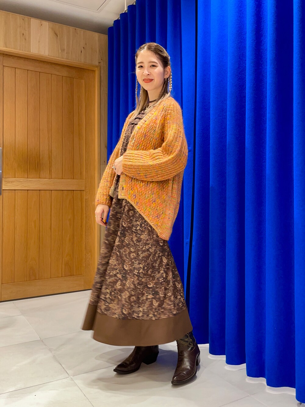 ブラウン系のワンピース、オレンジ系のカーディガン/ボレロを着用したレディースの秋コーディネートの2枚目の写真