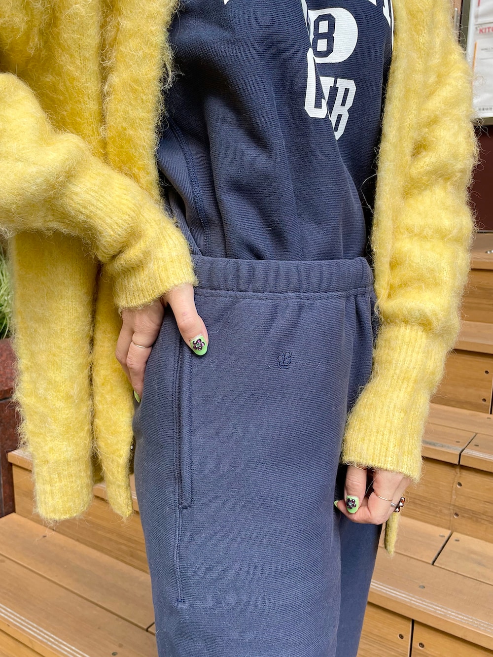 イエロー系のカーディガン/ボレロ、ブルー系のスウェットパンツ、ブルー系のスウェットを着用したレディースの秋コーディネートの5枚目の写真