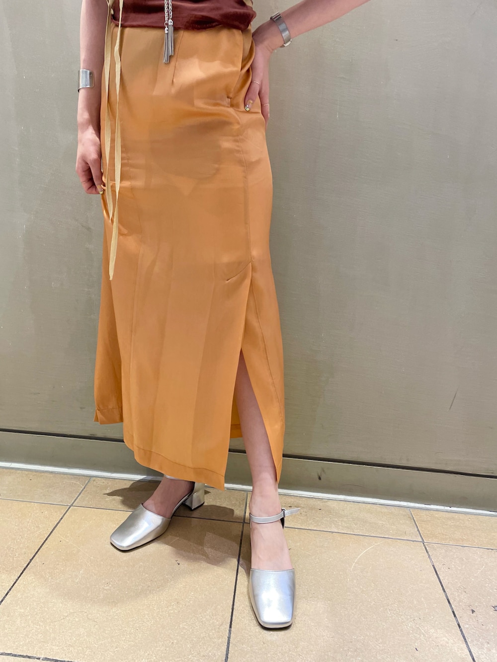 シルバー系のパンプス、ブラウン系のキャミソール、オレンジ系のワンピースを着用したレディースの夏コーディネートの5枚目の写真