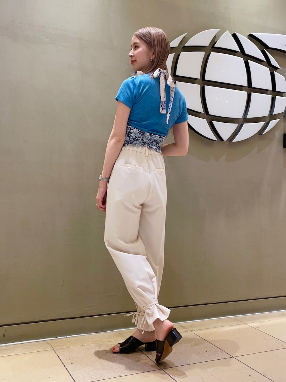 ホワイト系のその他パンツ、ブラック系のサンダル、ブルー系のTシャツ/カットソーを着用したレディースの春コーディネートの2枚目の写真