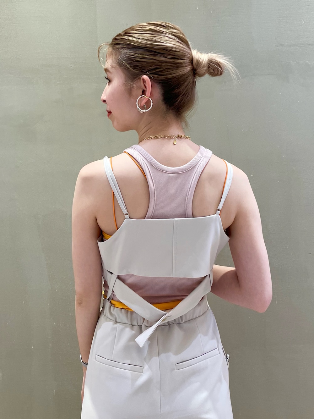 ホワイト系のサロペット/オーバーオール、オレンジ系のキャミソールを着用したレディースの夏コーディネートの5枚目の写真