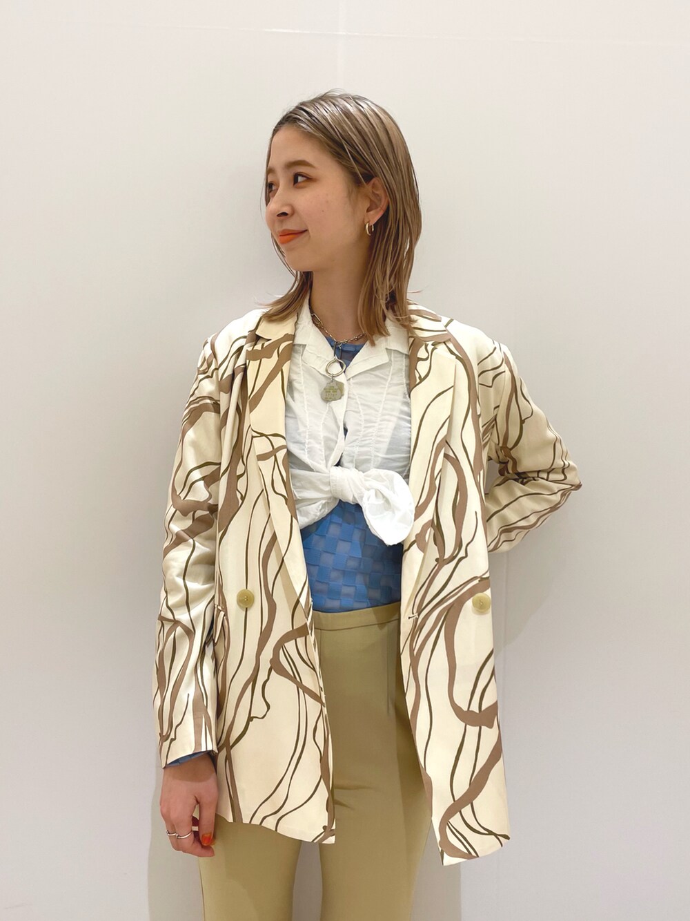 ホワイト系のテーラードジャケット、ホワイト系のシャツ/ブラウス、ブルー系のTシャツ/カットソーを着用したレディースの冬コーディネートの2枚目の写真