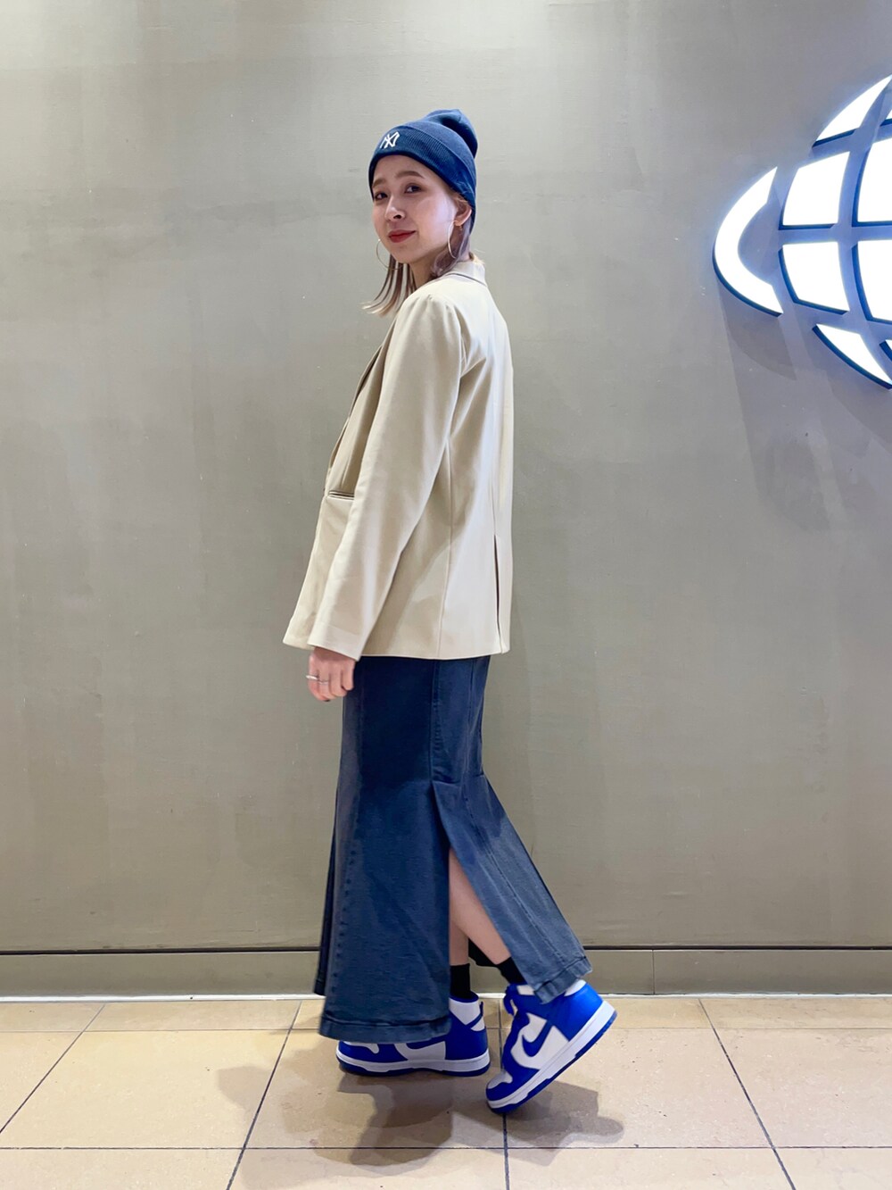 ブラック系のデニムスカート、ブルー系のニットキャップ/ビーニーを着用したレディースの冬コーディネートの2枚目の写真