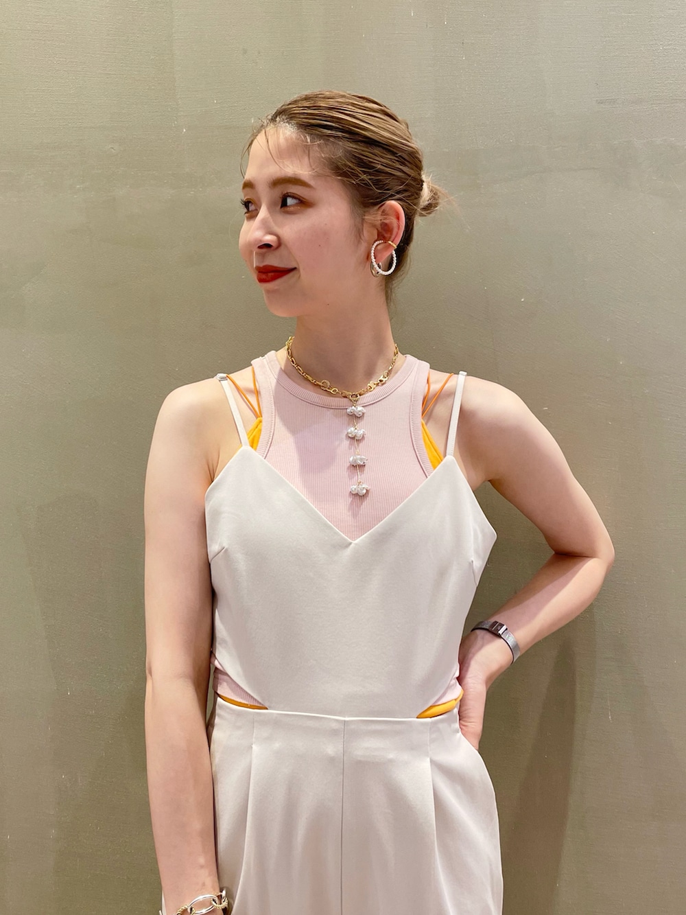 ホワイト系のサロペット/オーバーオール、オレンジ系のキャミソールを着用したレディースの夏コーディネートの2枚目の写真