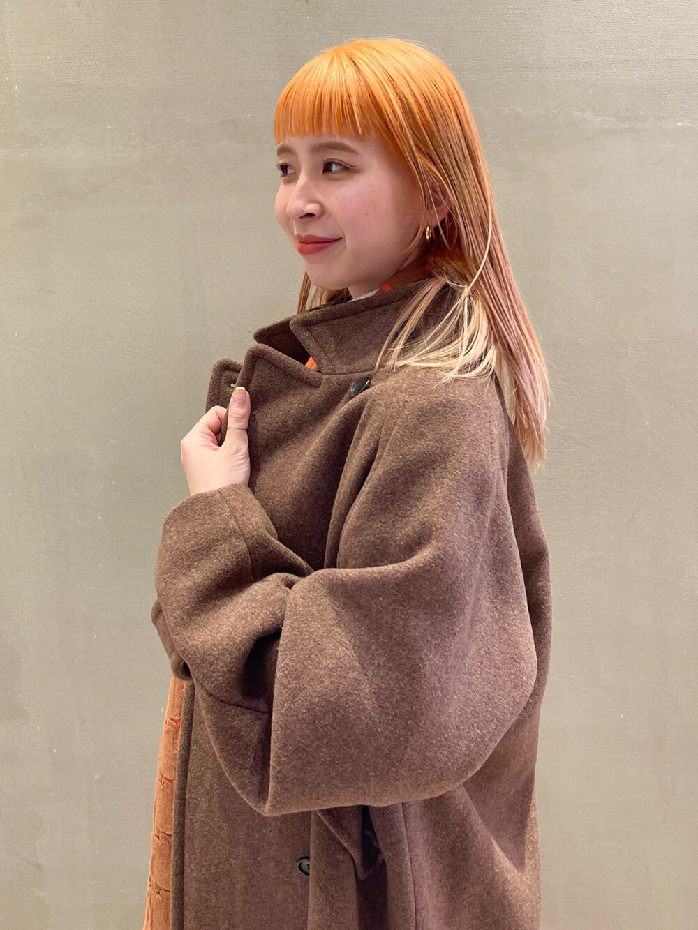 ブラウン系のその他アウター、ホワイト系のニット/セーター、ブラウン系のスカートを着用したレディースの秋コーディネートの2枚目の写真