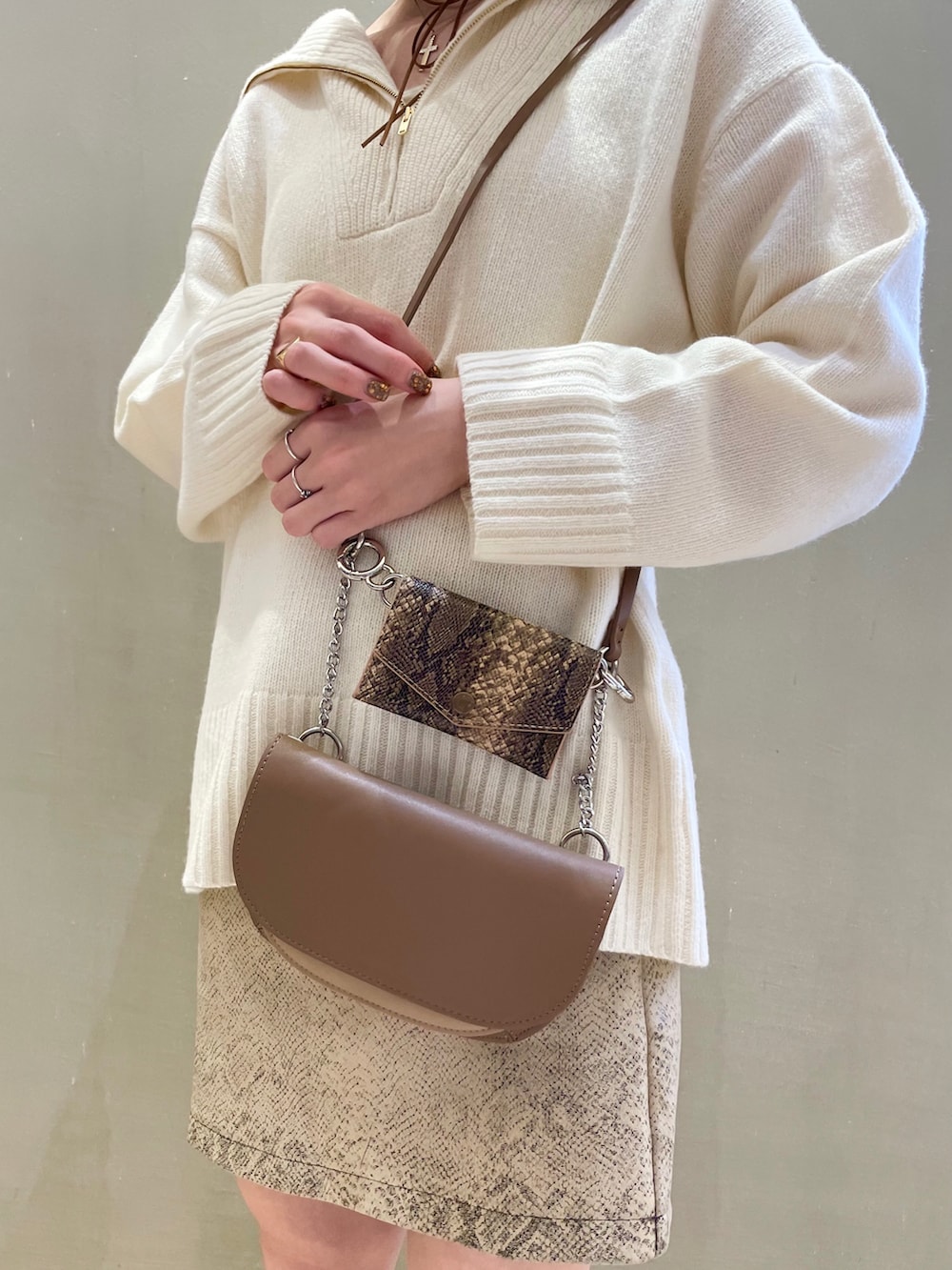 ホワイト系のニット/セーター、ベージュ系のショルダーバッグを着用したレディースの秋コーディネートの3枚目の写真