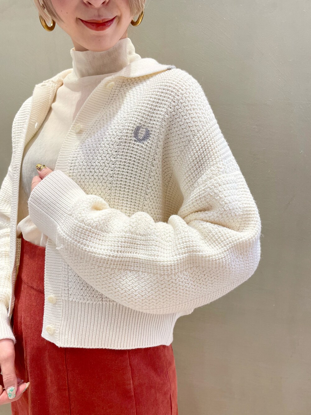 ホワイト系のカーディガン/ボレロ、ブラウン系のスカート、ホワイト系のTシャツ/カットソーを着用したレディースの秋コーディネートの3枚目の写真