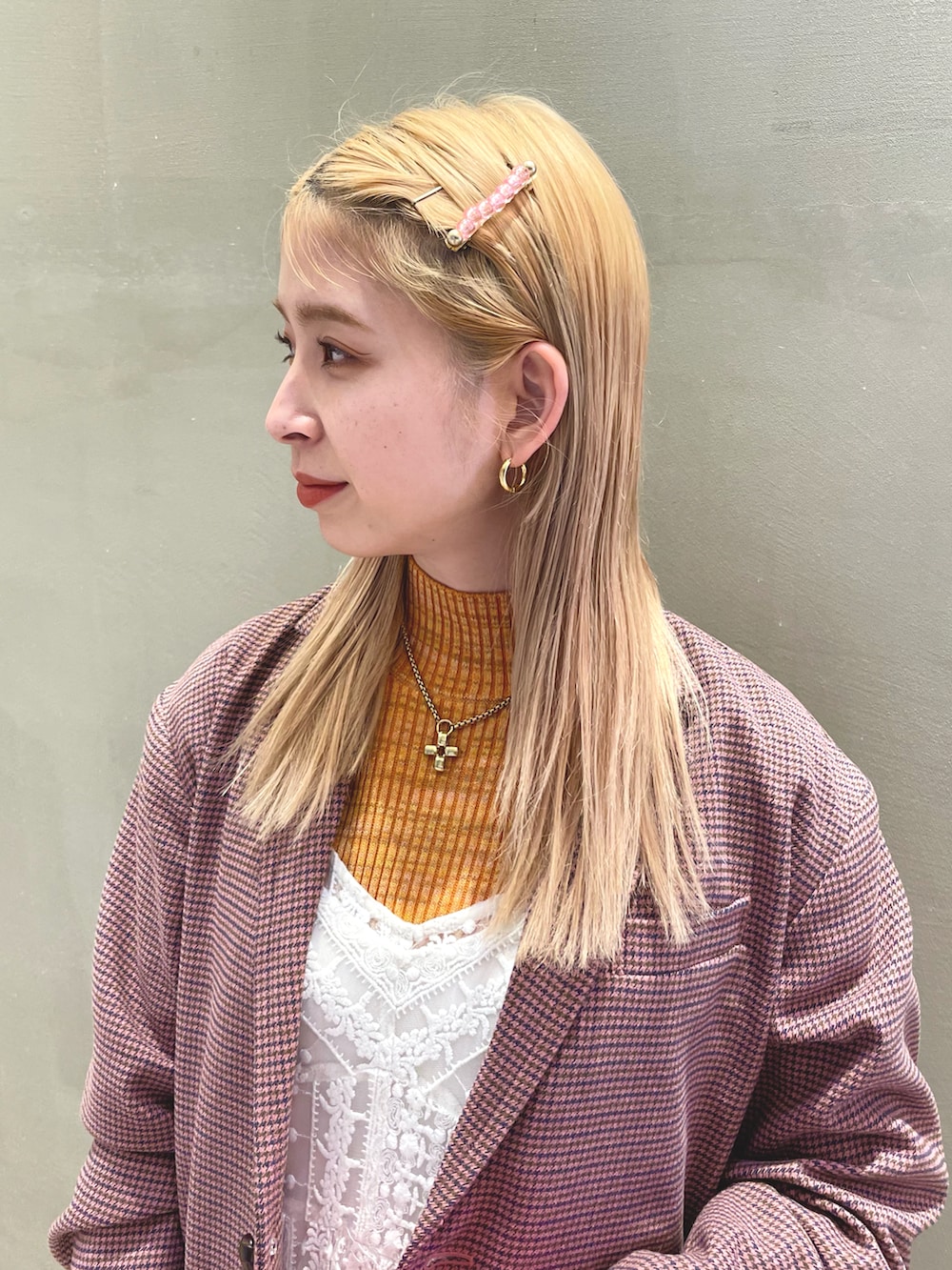 ピンク系のテーラードジャケット、オレンジ系のニット/セーター、ピンク系の手袋を着用したレディースの秋コーディネートの5枚目の写真