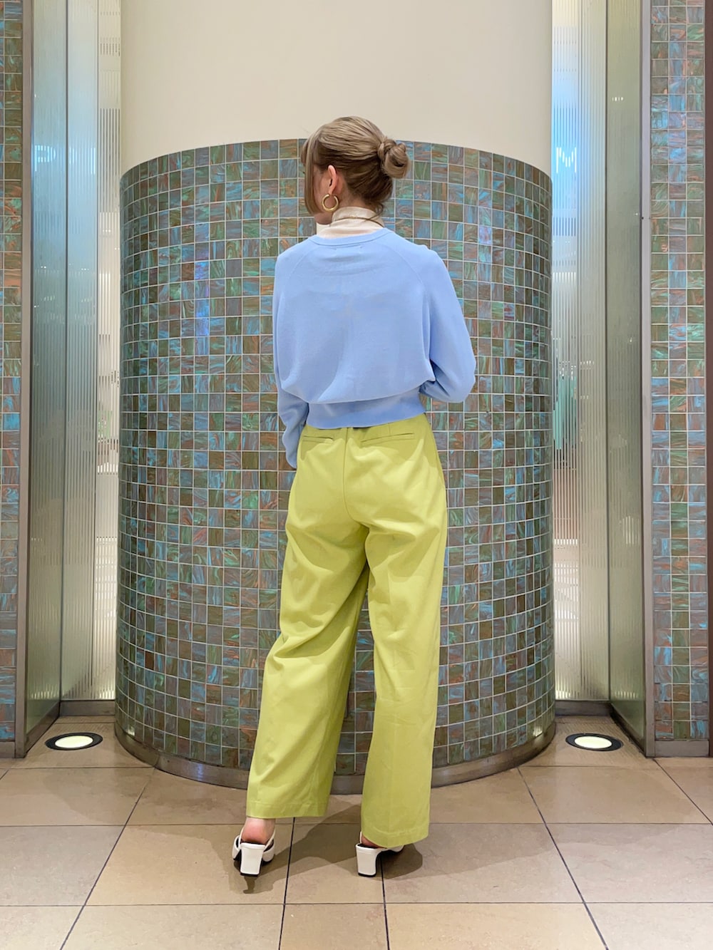 グリーン系のパンツ、ブルー系のカーディガン/ボレロ、ホワイト系のTシャツ/カットソーを着用したレディースの冬コーディネートの2枚目の写真