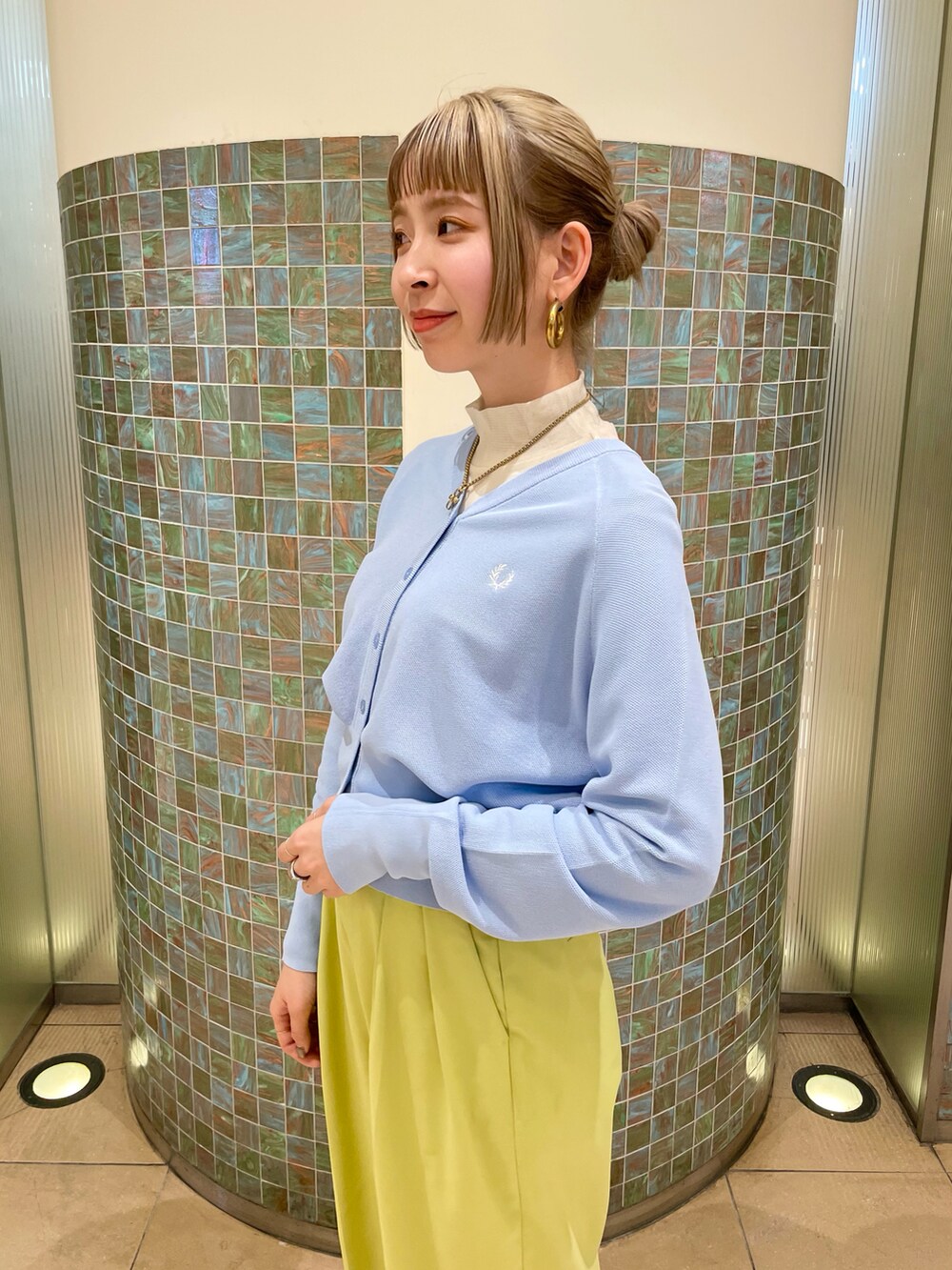 グリーン系のパンツ、ブルー系のカーディガン/ボレロ、ホワイト系のTシャツ/カットソーを着用したレディースの冬コーディネートの3枚目の写真