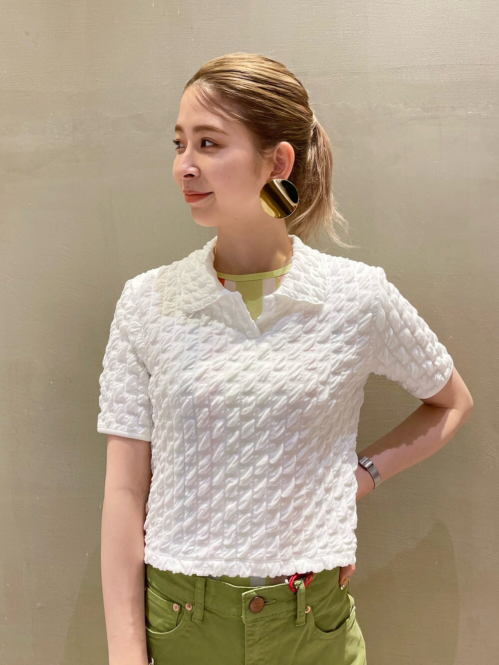 グリーン系のデニムパンツ、ホワイト系のサンダルを着用したレディースの夏コーディネートの2枚目の写真