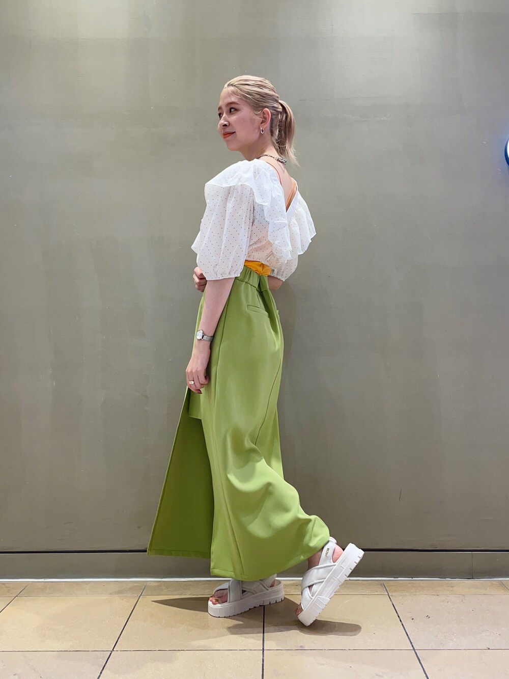 グリーン系のスカート、ホワイト系のシャツ/ブラウス、オレンジ系のキャミソールを着用したレディースの夏コーディネートの2枚目の写真