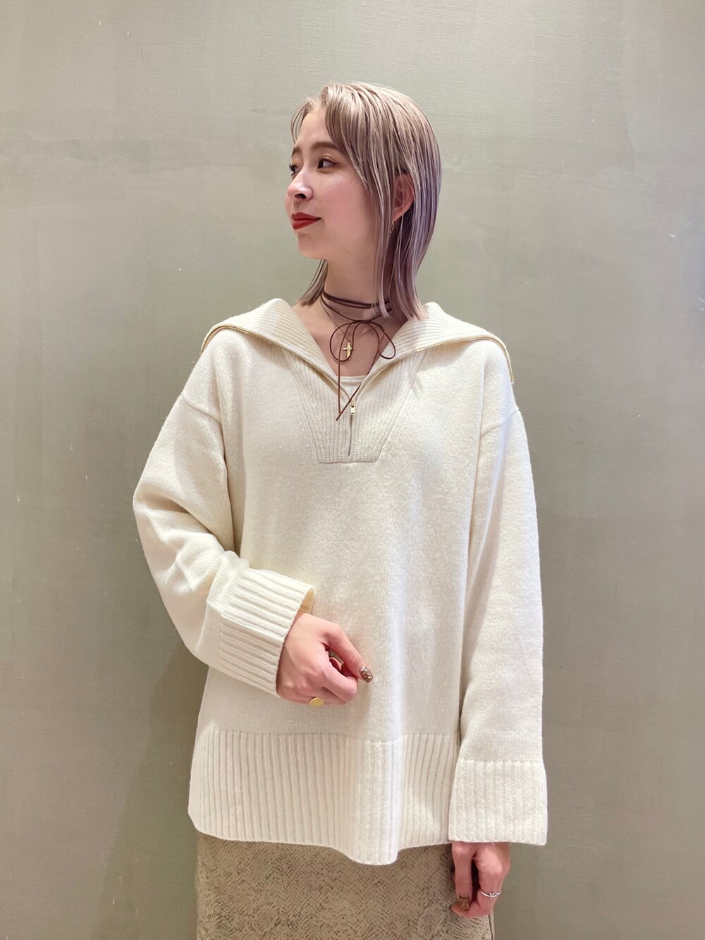 ホワイト系のニット/セーター、ベージュ系のショルダーバッグを着用したレディースの秋コーディネートの2枚目の写真