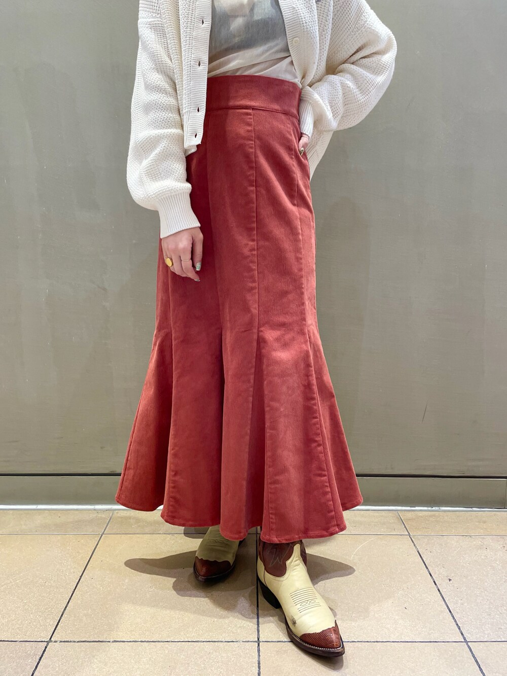 ホワイト系のカーディガン/ボレロ、ブラウン系のスカート、ホワイト系のTシャツ/カットソーを着用したレディースの秋コーディネートの4枚目の写真