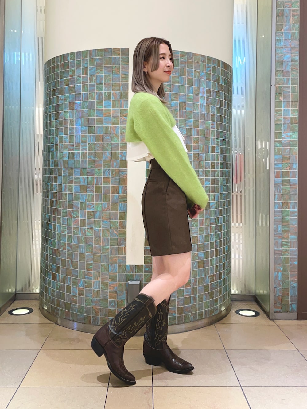 ブラウン系のその他パンツ、グリーン系のニット/セーターを着用したレディースの秋コーディネートの2枚目の写真