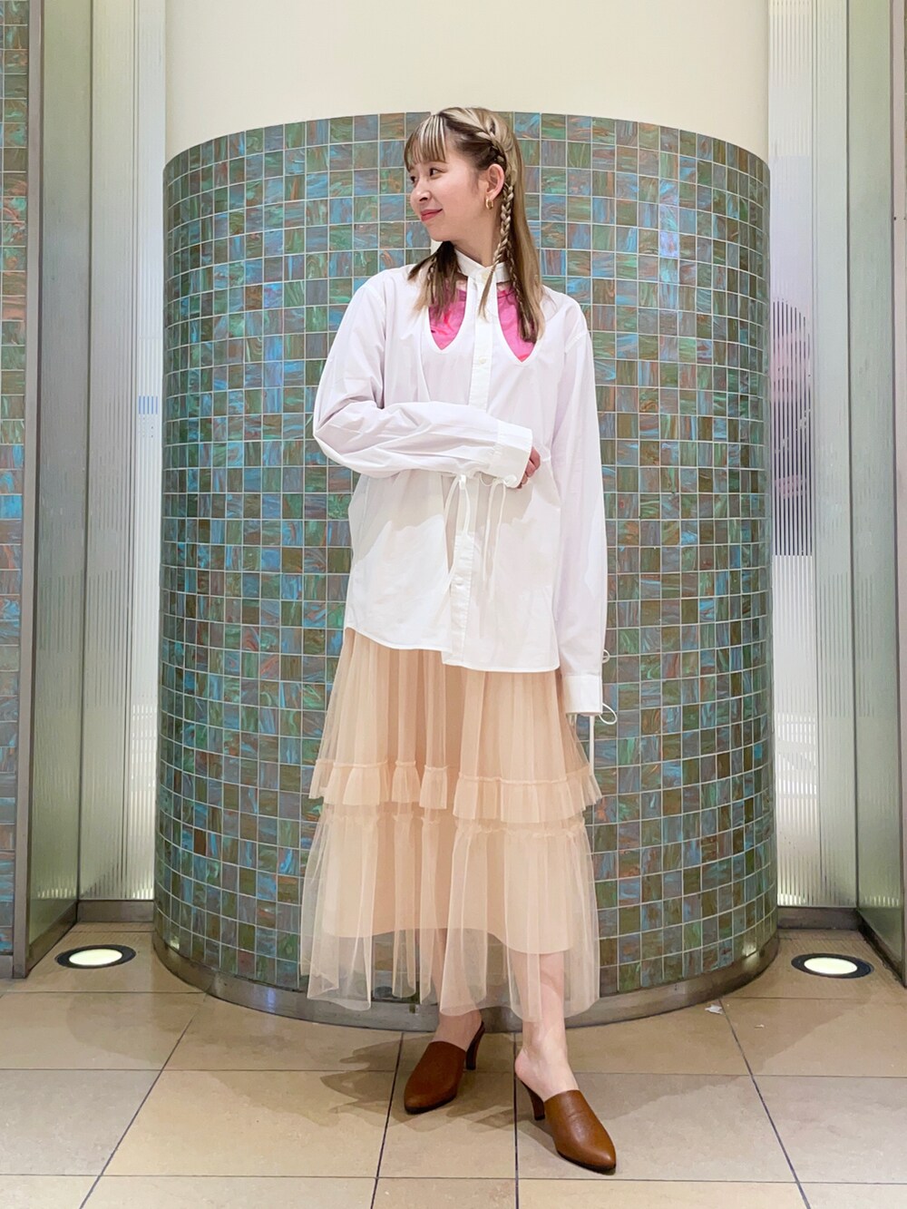 ベージュ系のスカート、ピンク系のトップスを着用したレディースの冬コーディネートの2枚目の写真