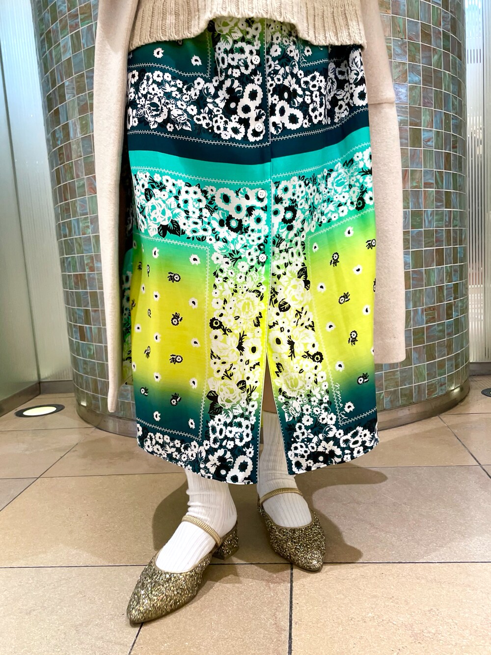 ホワイト系のノーカラーコートを着用したレディースの冬コーディネートの4枚目の写真