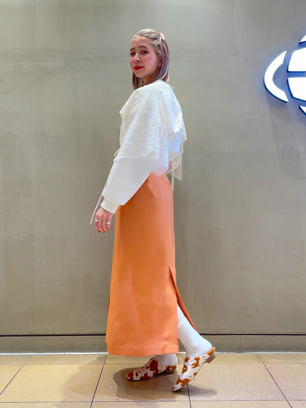 オレンジ系のスカート、その他のその他シューズ、ホワイト系の付け襟を着用したレディースの冬コーディネートの2枚目の写真