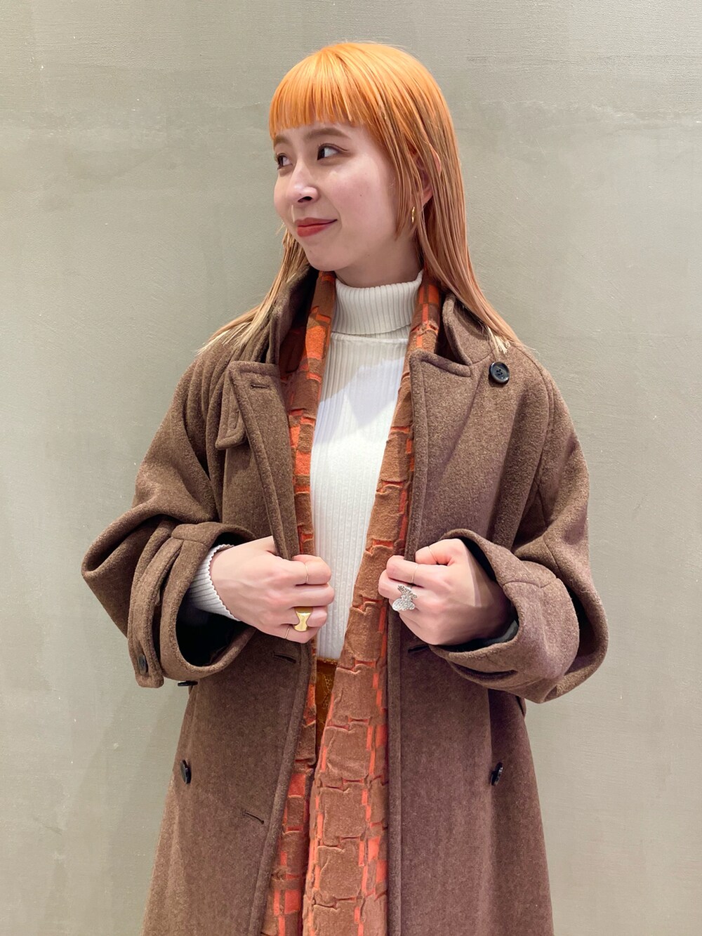 ブラウン系のその他アウター、ホワイト系のニット/セーター、ブラウン系のスカートを着用したレディースの秋コーディネートの3枚目の写真