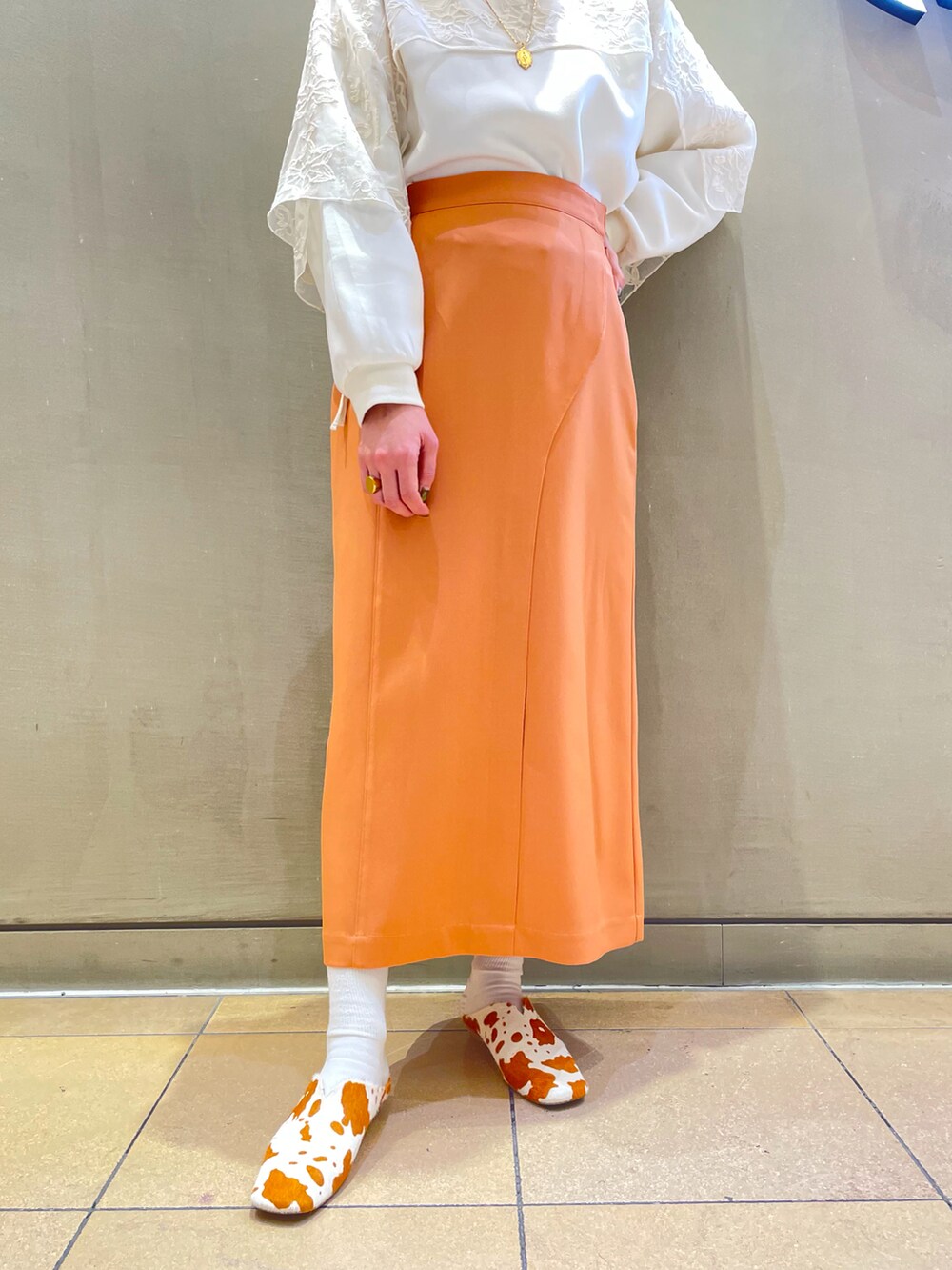 オレンジ系のスカート、その他のその他シューズ、ホワイト系の付け襟を着用したレディースの冬コーディネートの5枚目の写真