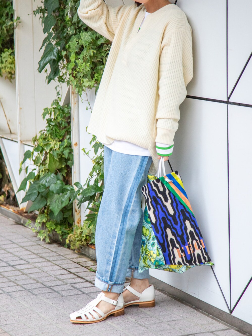 その他のトートバッグ、ブルー系のデニムパンツ、ベージュ系のトップスを着用したレディースの冬コーディネートの2枚目の写真